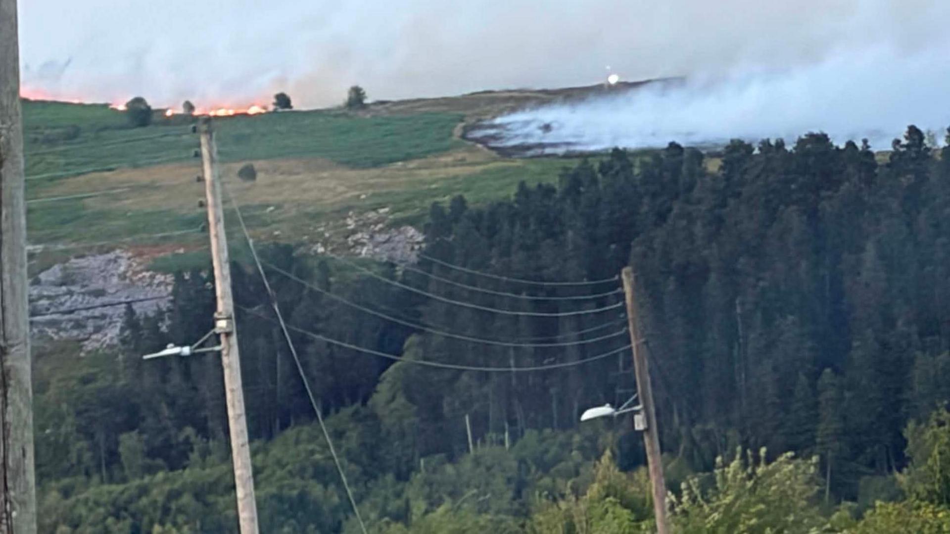 A wide seat of fire across a sprawling hillside