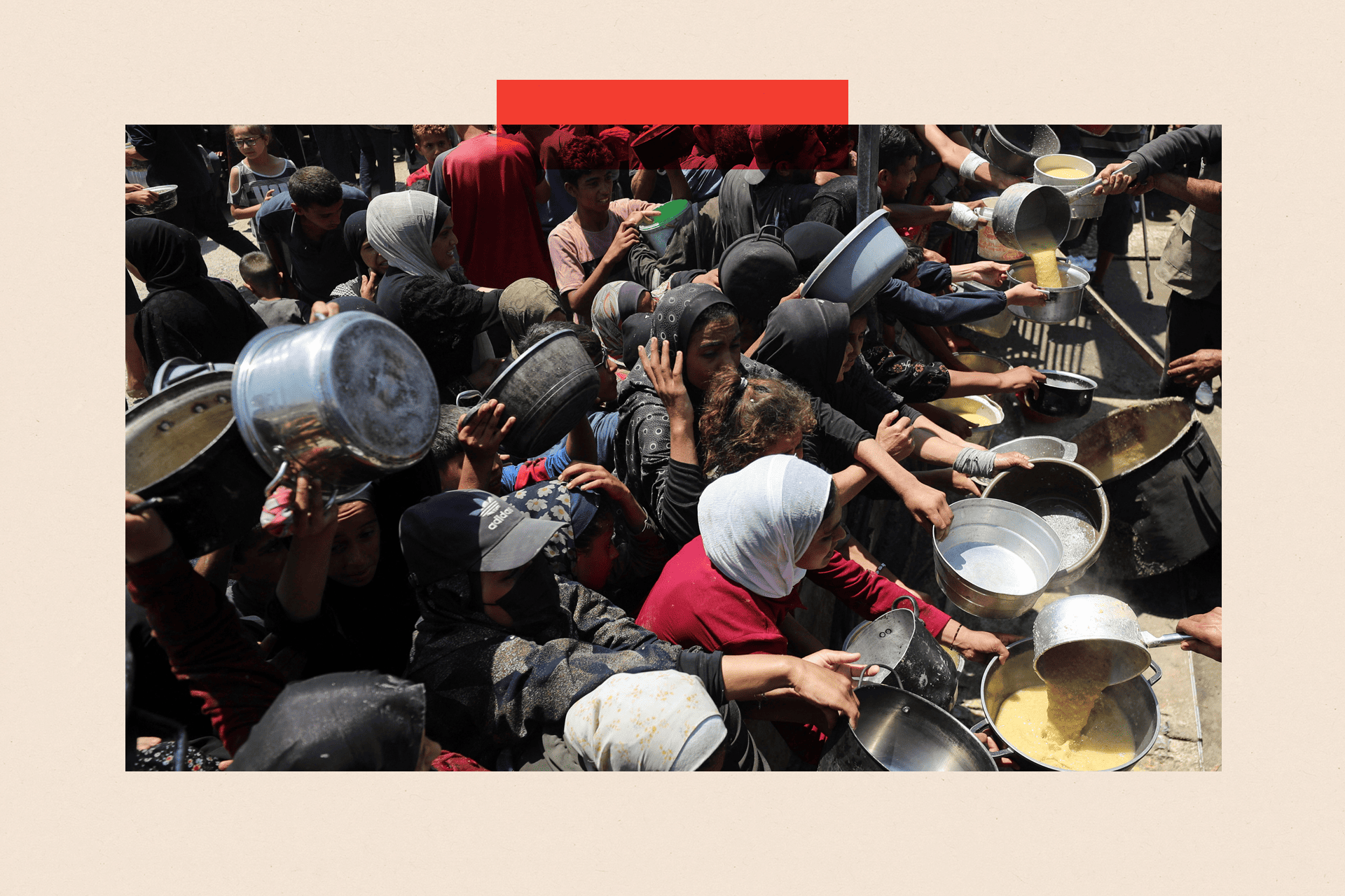 Palestinians wait to receive food from a charity kitchen