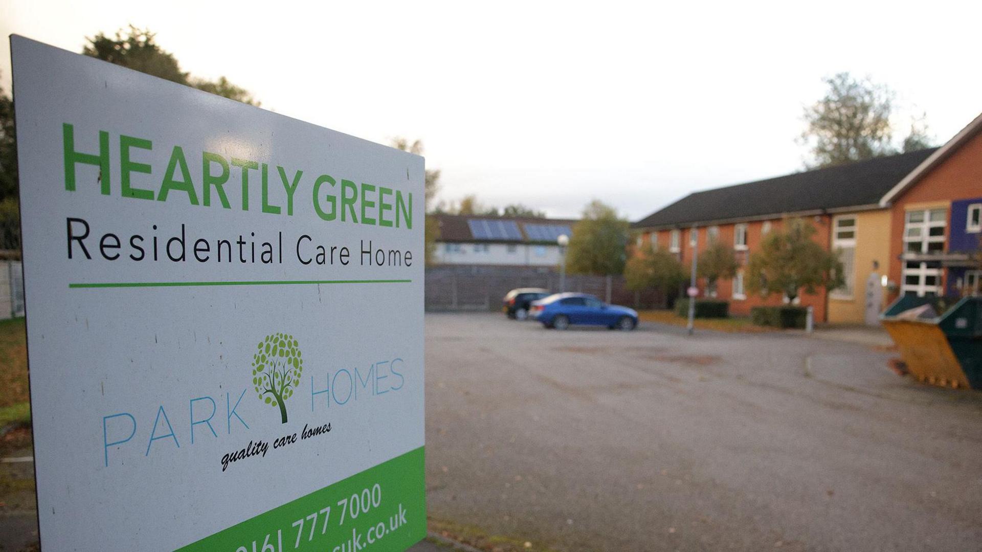 A white and green Heartly Green sign at the entrance to the care home