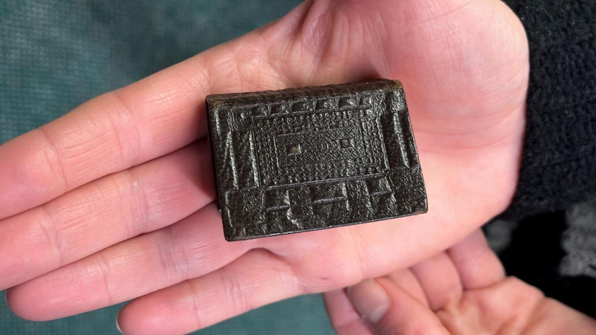 A close-up of a tiny bible which is being held in the palm of a hand