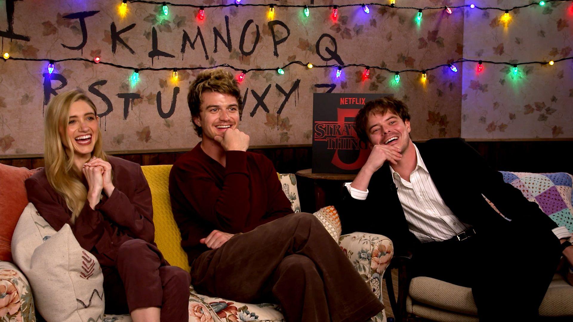 Stranger Things' Natalia Dyer, Joe Keery and Charlie Heaton sat on a sofa and laughing