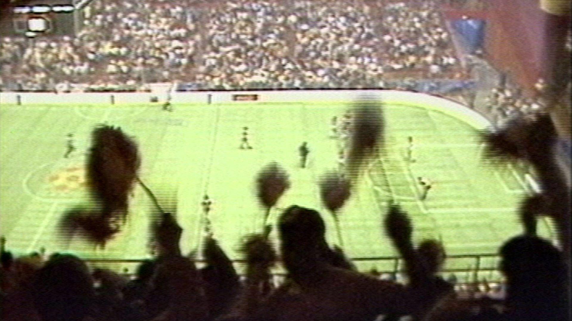 A silhouetted crowd watching a soccer match