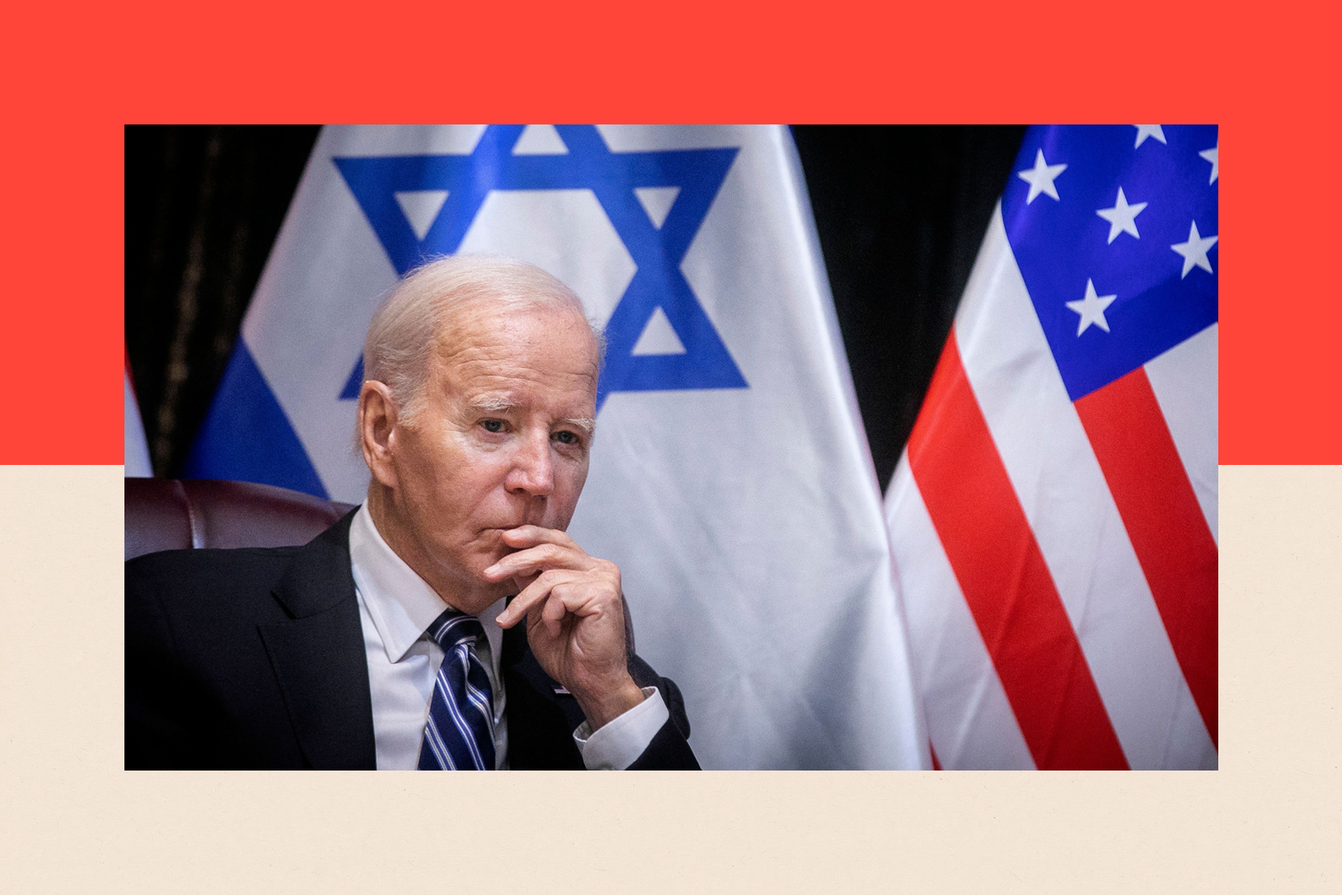 US President Joe Biden with his hand to his face, as he sits in front of flags
