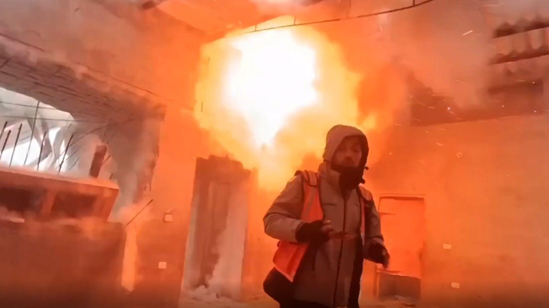 An explosion behind a man entering a building