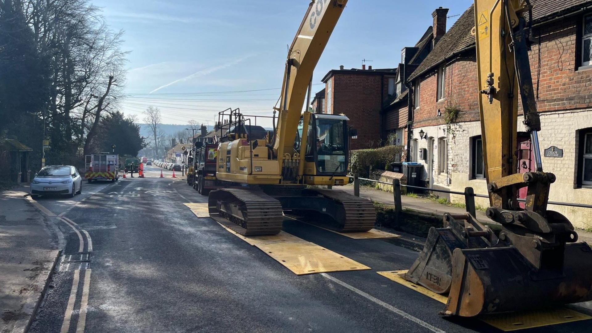 A yellow excavator brought in to deal with a sinkhole in Godstone High Street.