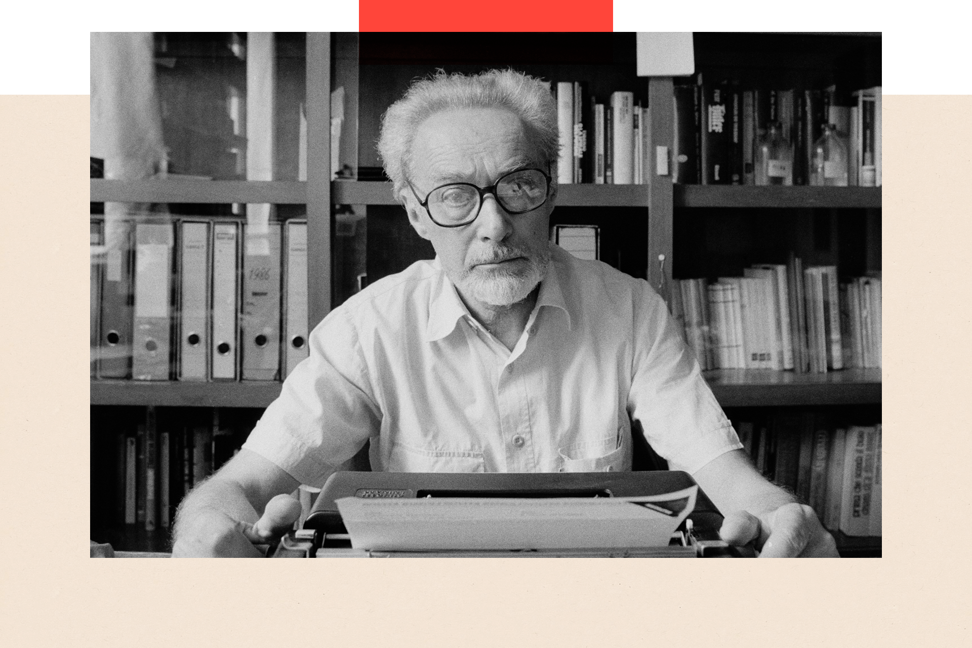 Author, Primo Levi, in 1986, sitting in front of a bookshelf with a typewriter