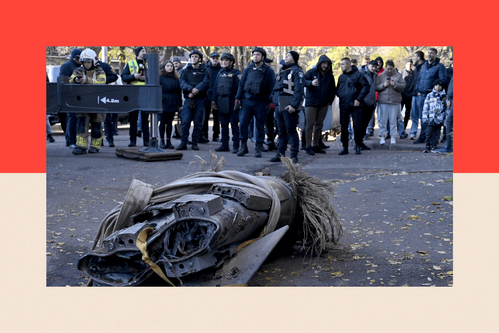The remains of a downed Russian hypersonic missile Zircon, after it struck a residential building in Kyiv - in the background a crowd looks on