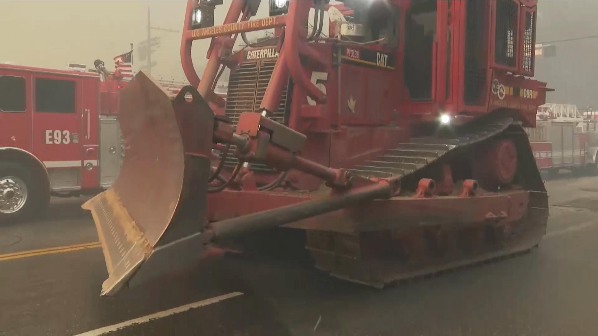 Bulldozer headed to remove cars.