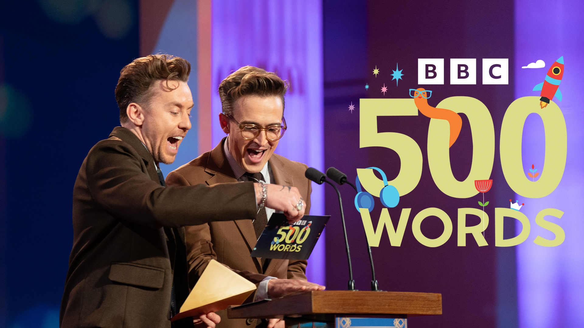 Danny Jones and Tom Fletcher reading from a 500 Words card. 