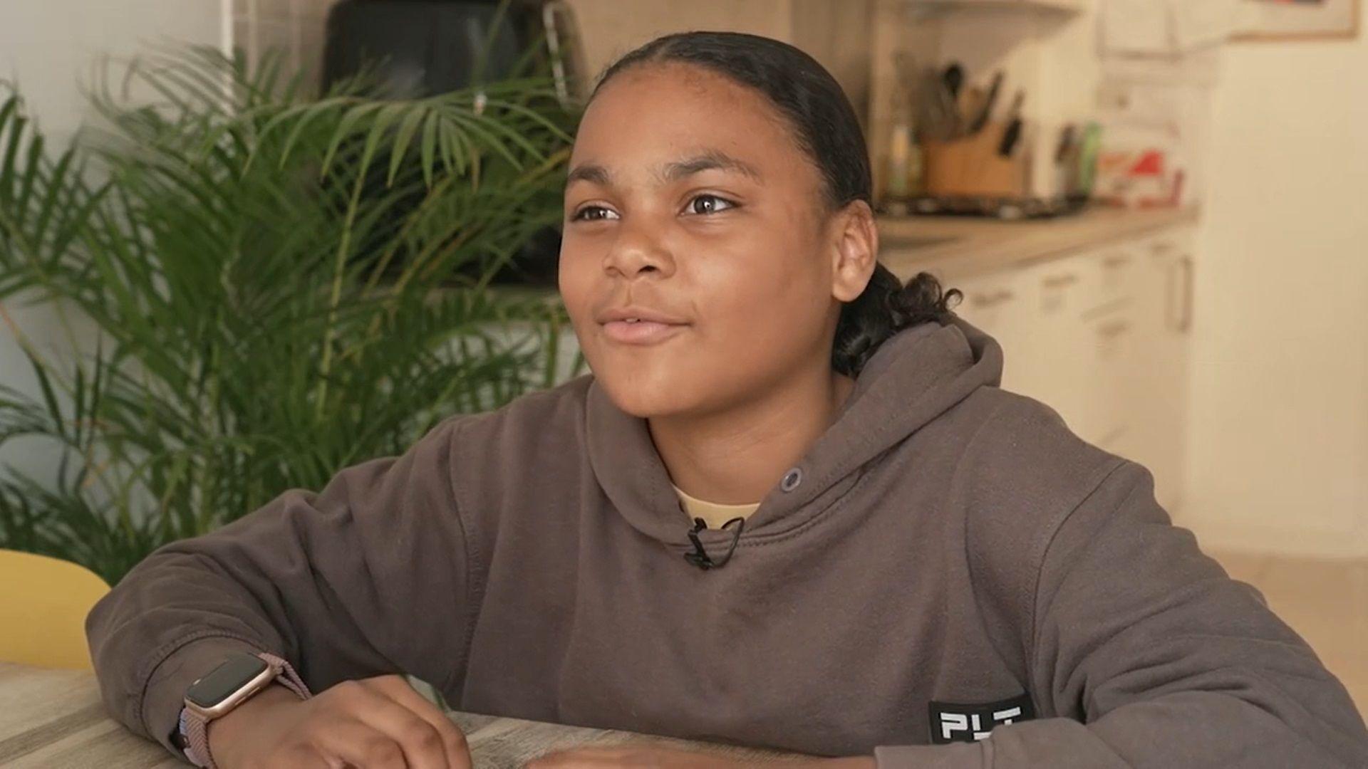 Twelve-year-old Tahlia sitting at a table while being interviewed. 