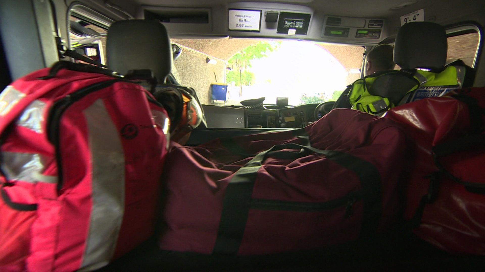 Inside a dark truck with red bags of equipment