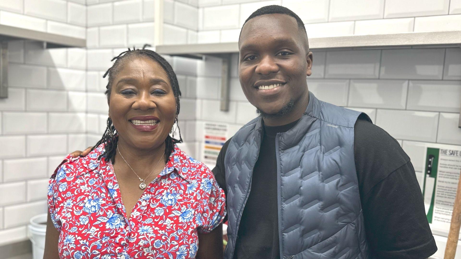 Kelvin Adabla and mum Rebecca smile in their kitchen on Holloway Road in north London. 