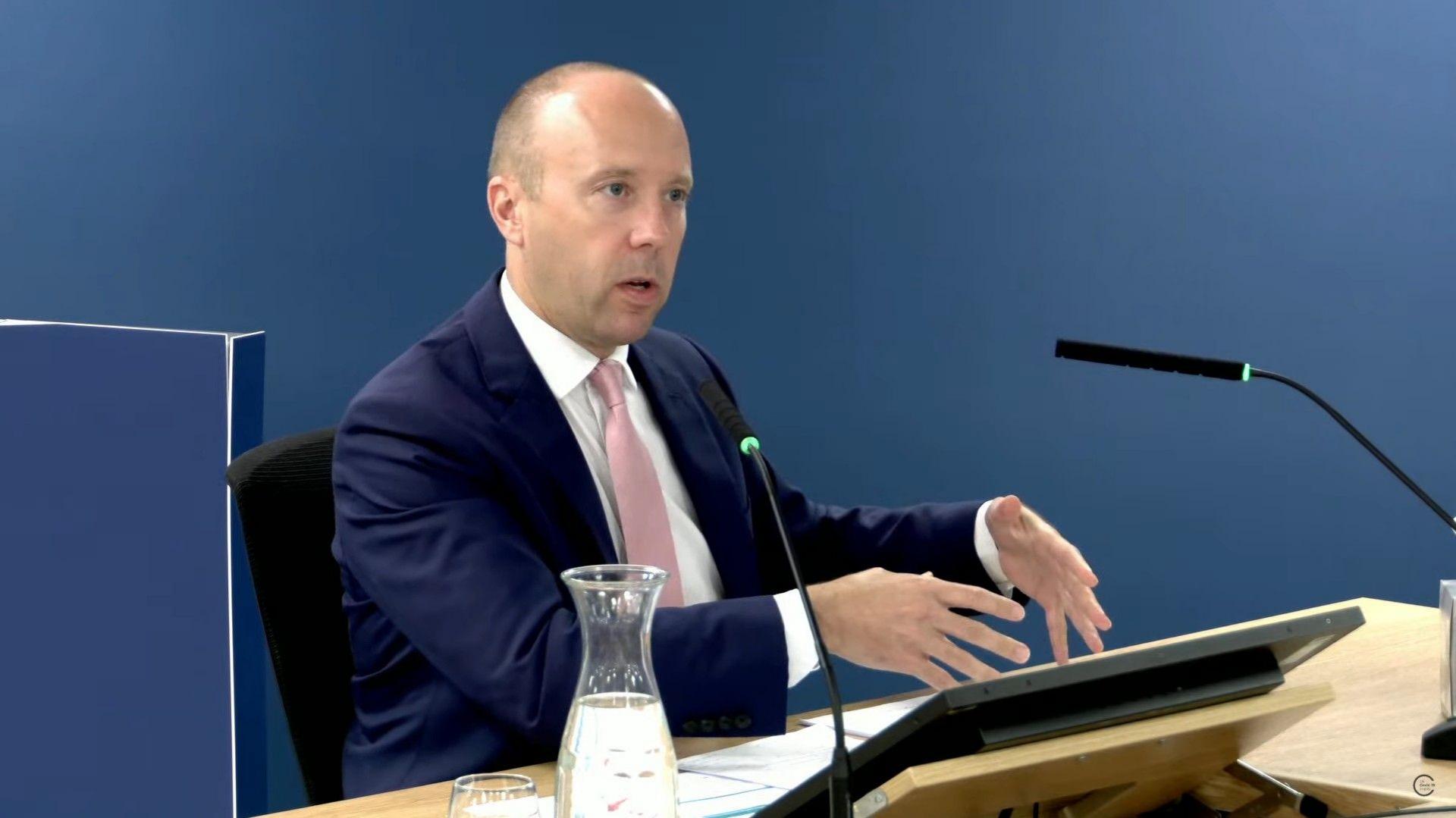 Matt Hancock wearing a blue suit and a light pink tie, sitting at a lectern at the Covid Inquiry on Wednesday. 