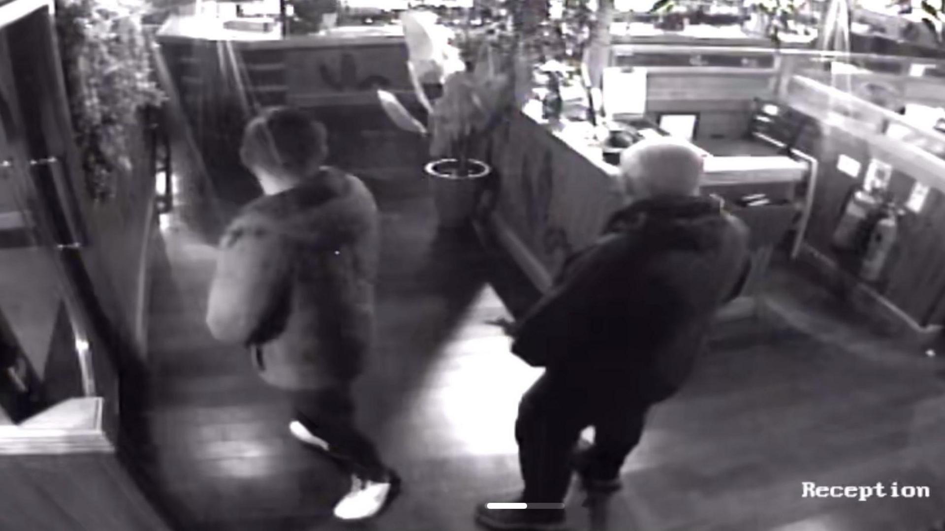 CCTV footage of the inside of their restaurant with the back of two men in forefront