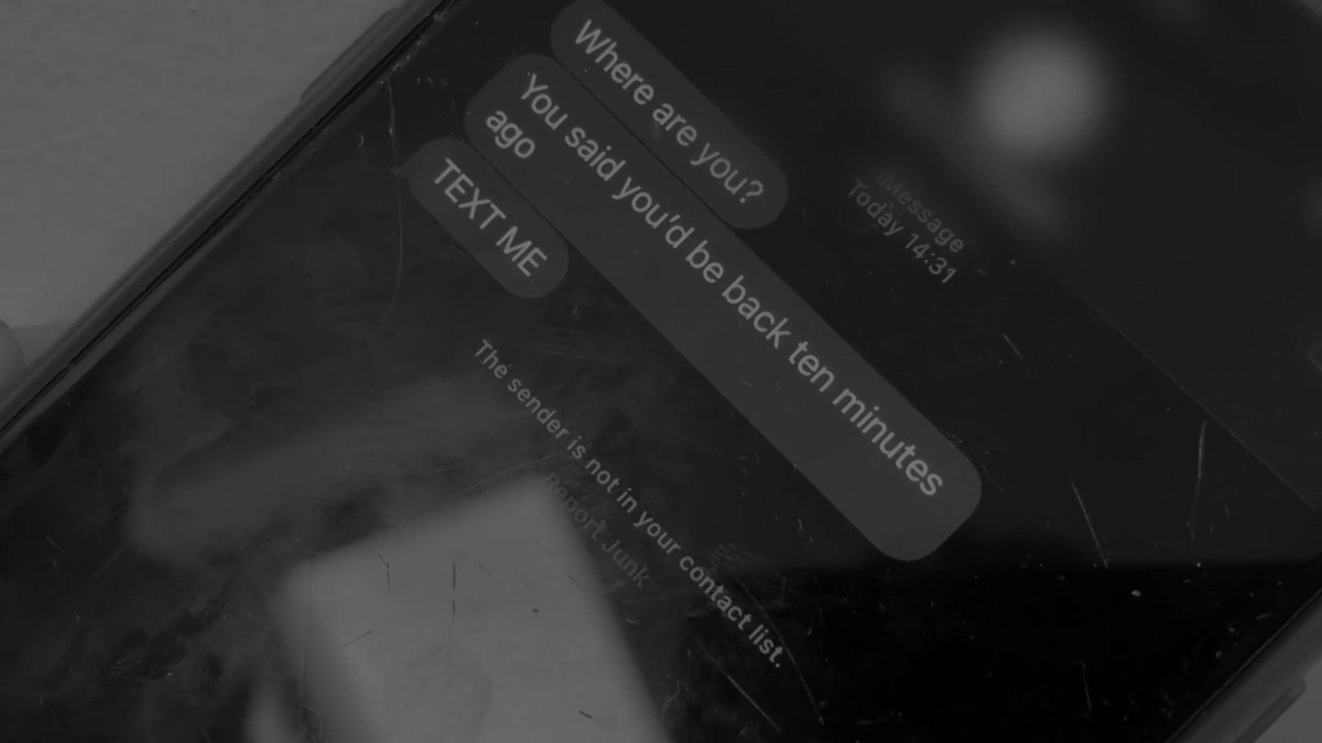 A black smartphone bearing text messages all from one sender. They read "where are you?", "You said you'd be back ten minutes ago", and "text me", all in upper case.