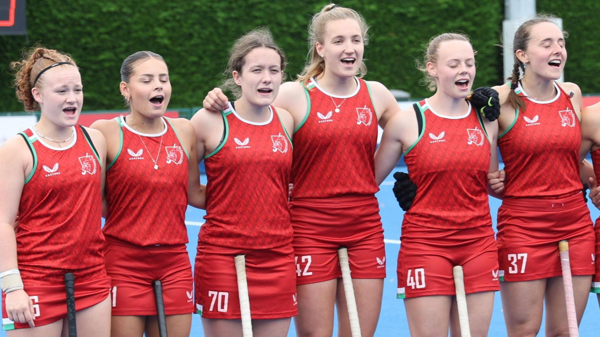 Members of the Wales women's team sing the national anthem 