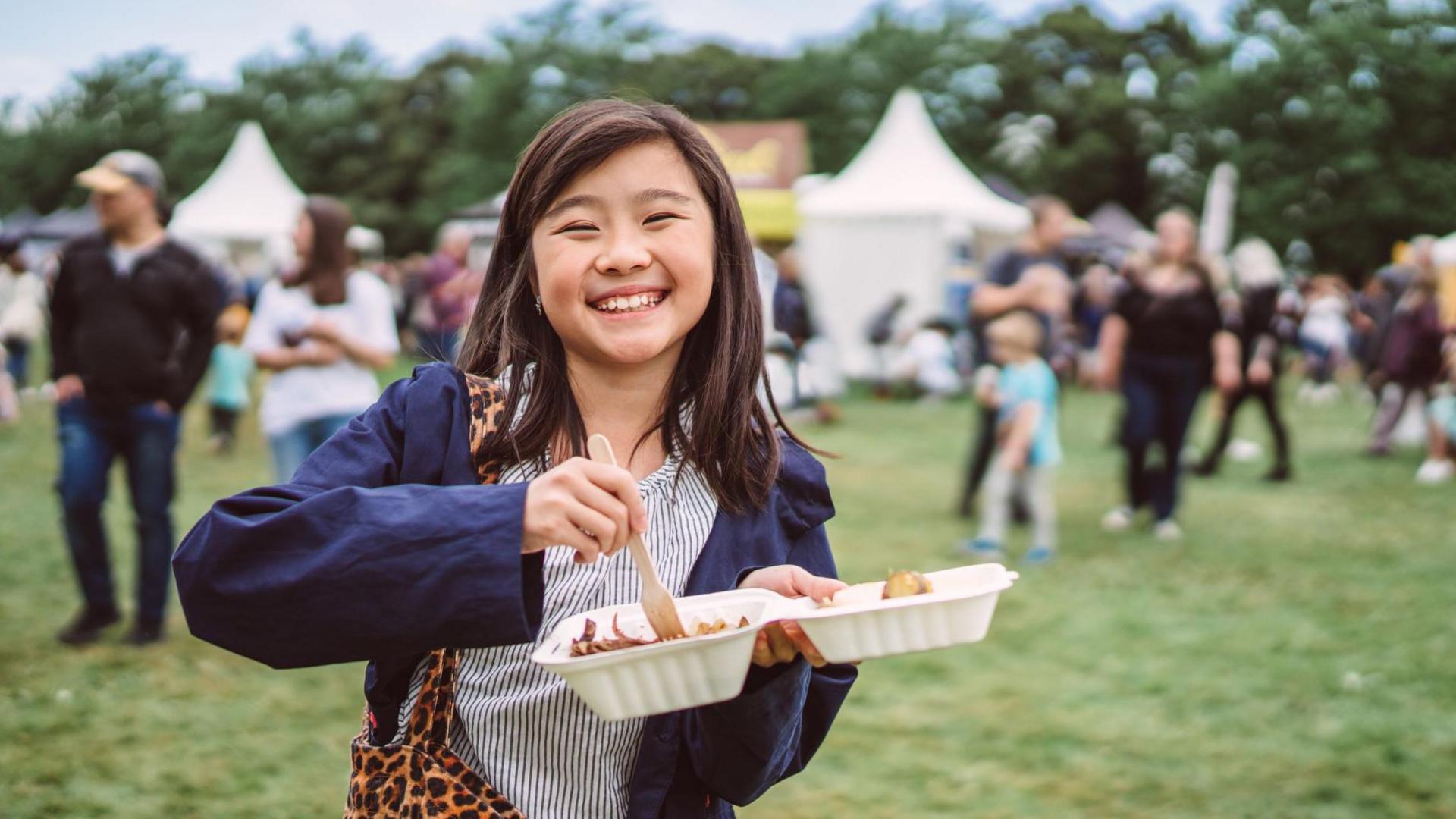 Girl eating at festival. 