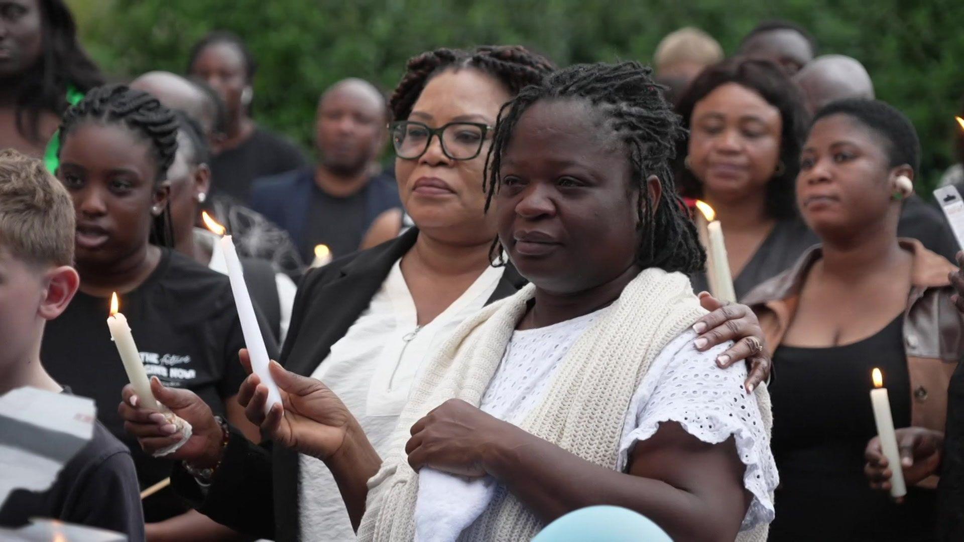 Mourners at the vigil holding lit candles.