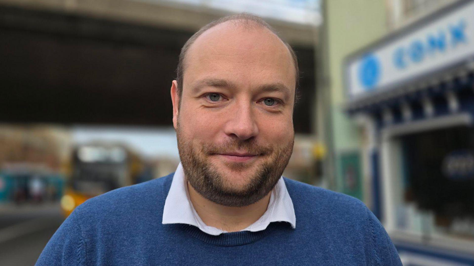 Martin Schmierer has a close-cropped beard and is wearing a blue jumper and open-necked shirt.