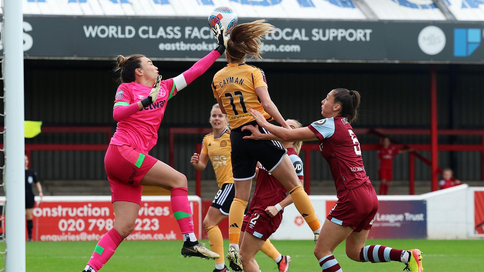 Mackenzie Arnold of West Ham United makes a save whilst under pressure from Janice Cayman of Leicester City