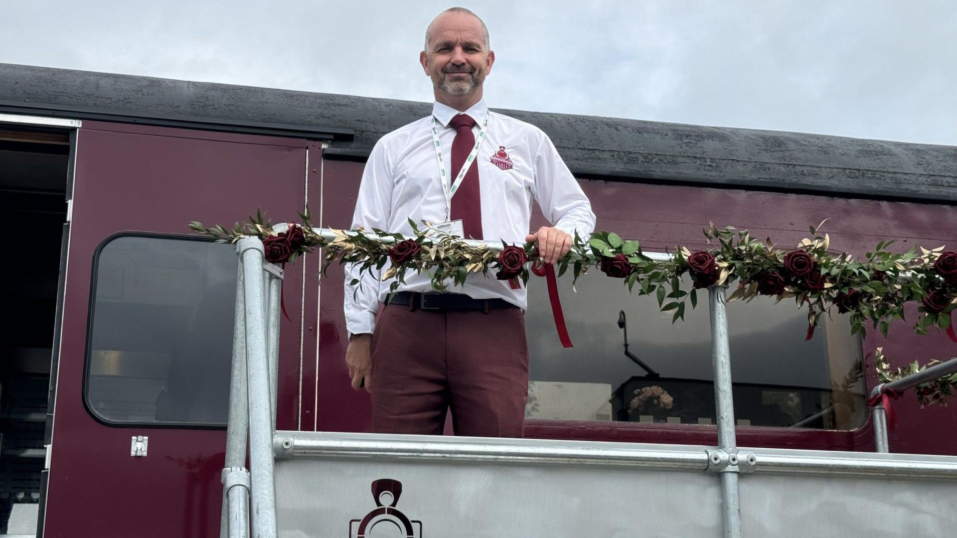 Head teacher Tim Williams stands at the entrance to the Fawrient Express train carriage