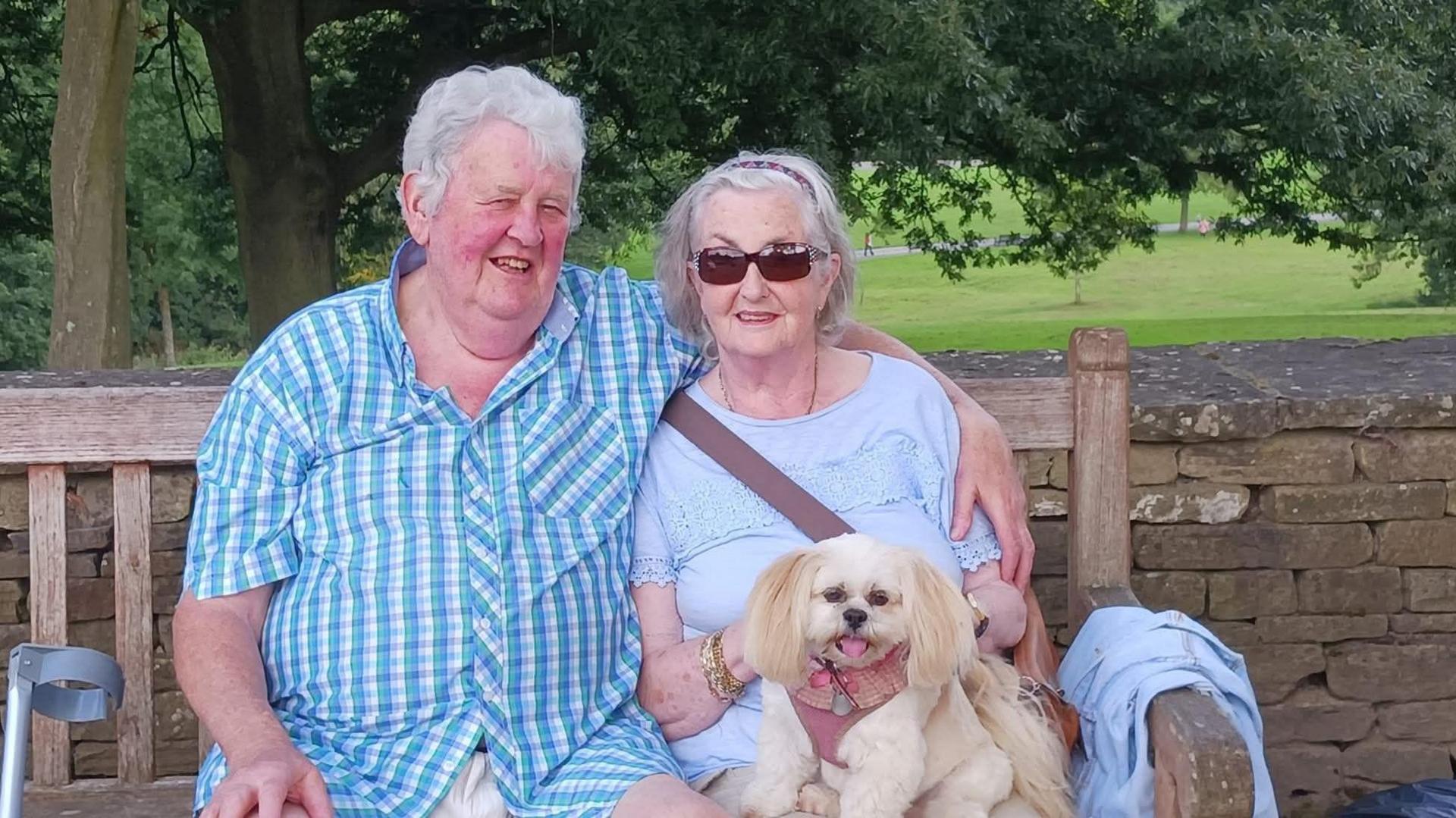 Lee and Susan Ashworth sat on a bench with their dog.