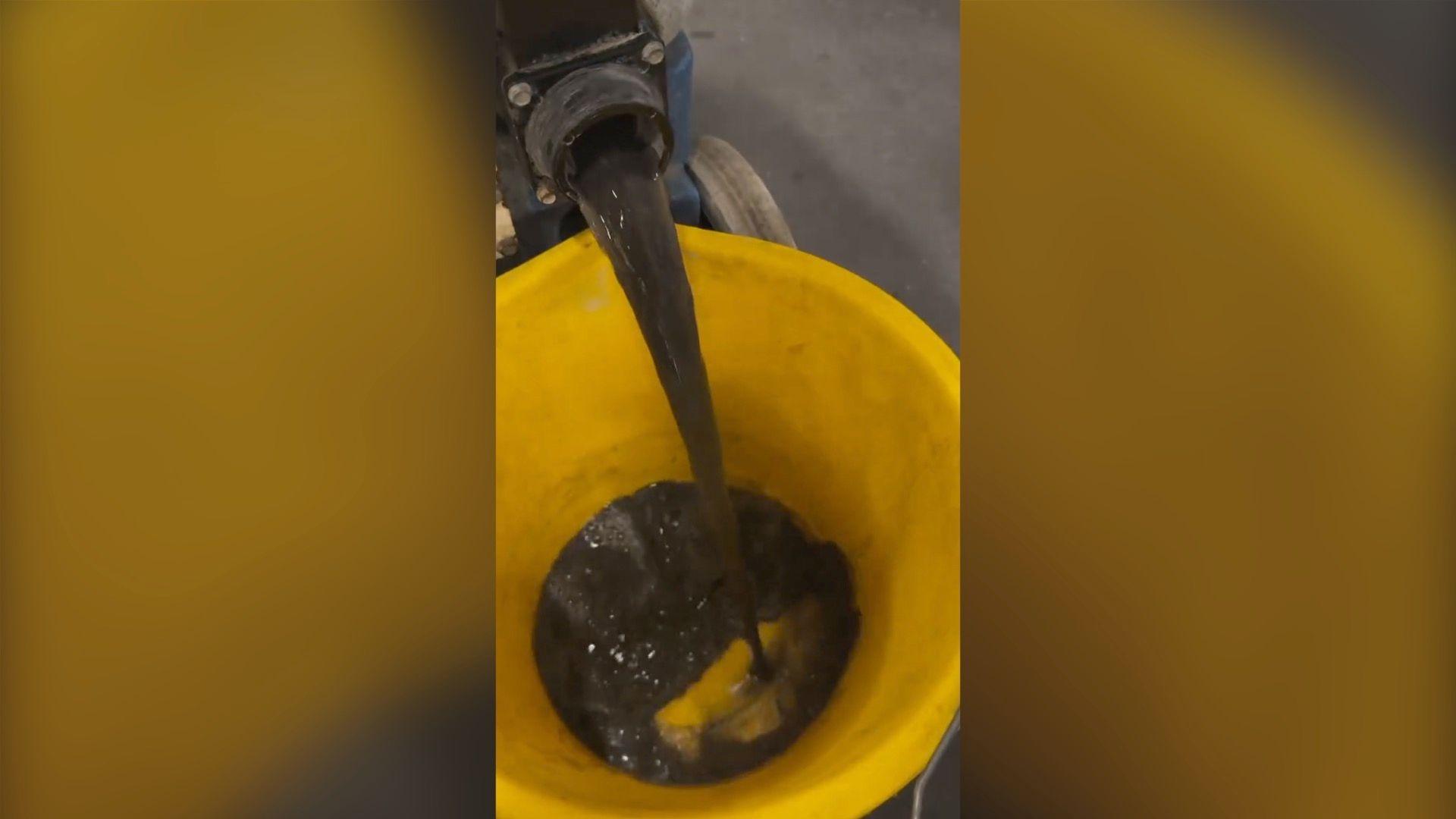 Black liquid pours from with fluid collected from Tube seats into bucket