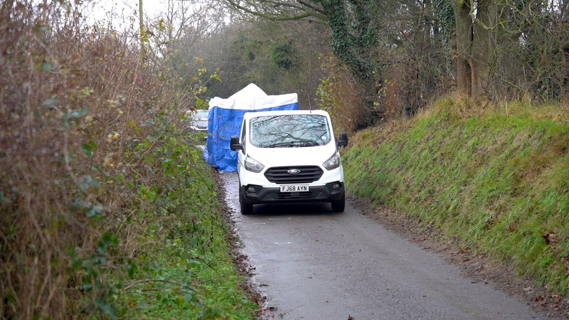 Police vehicle in Batley Lane with blue tent in the background