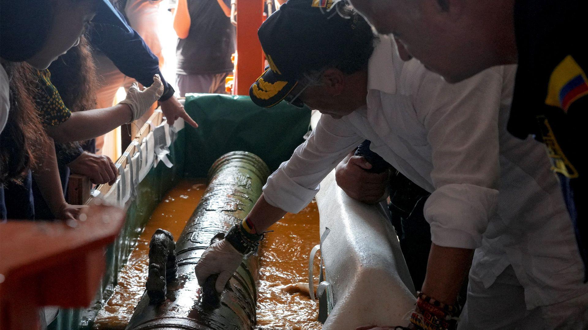 Colombian President Gustavo Petro looking at a bronze cannon from the wreck of the San José.
