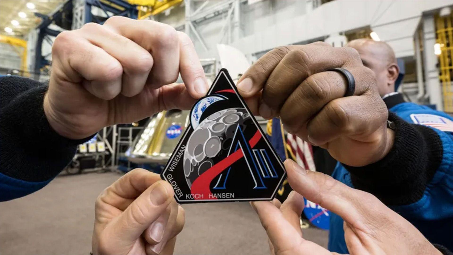 The Artemis II astronauts holding the Artemis II patch at Nasa