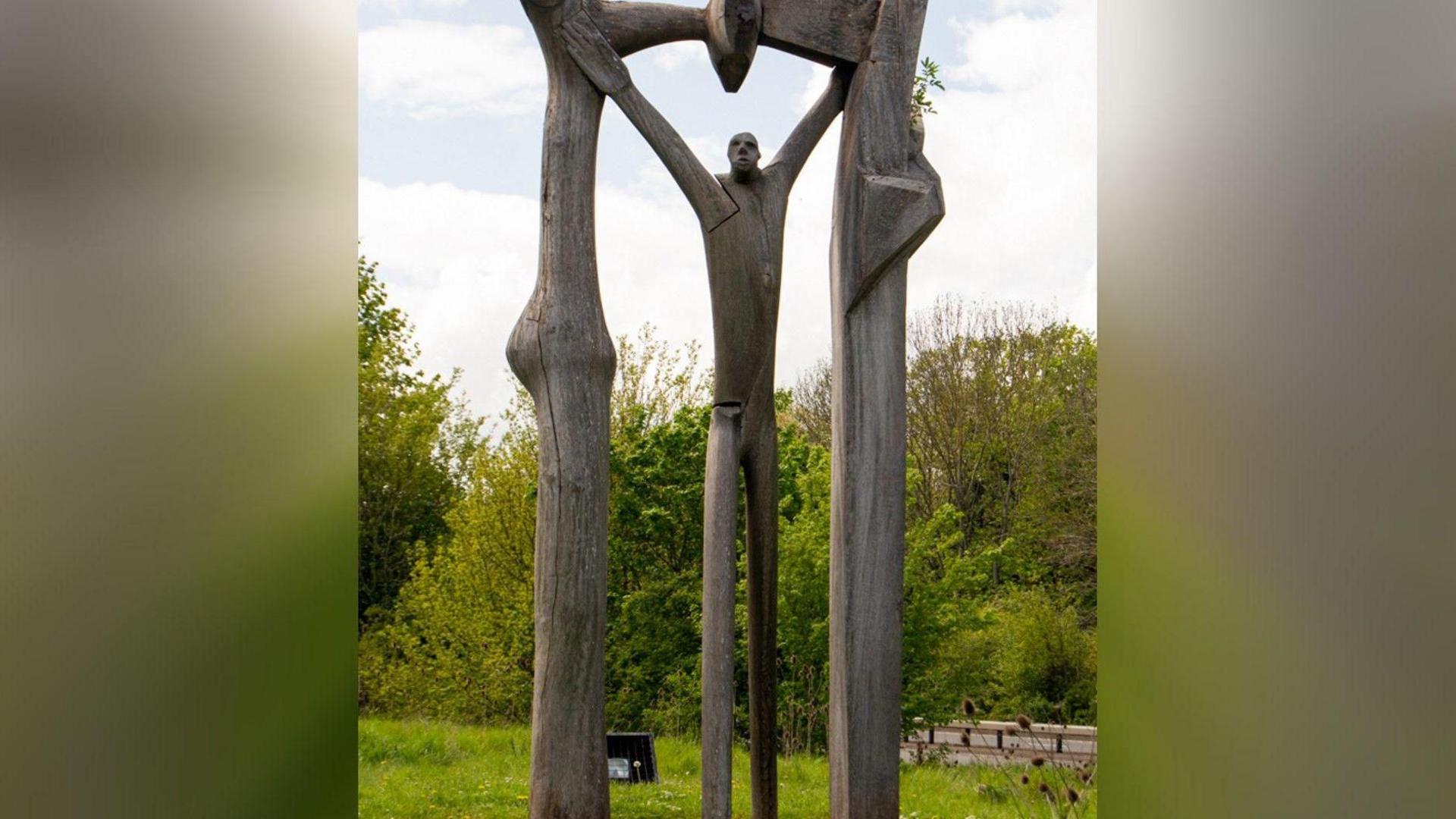 The Peterborough Arch is an abstract sculpture of a wooden man standing under a wooden arch.
