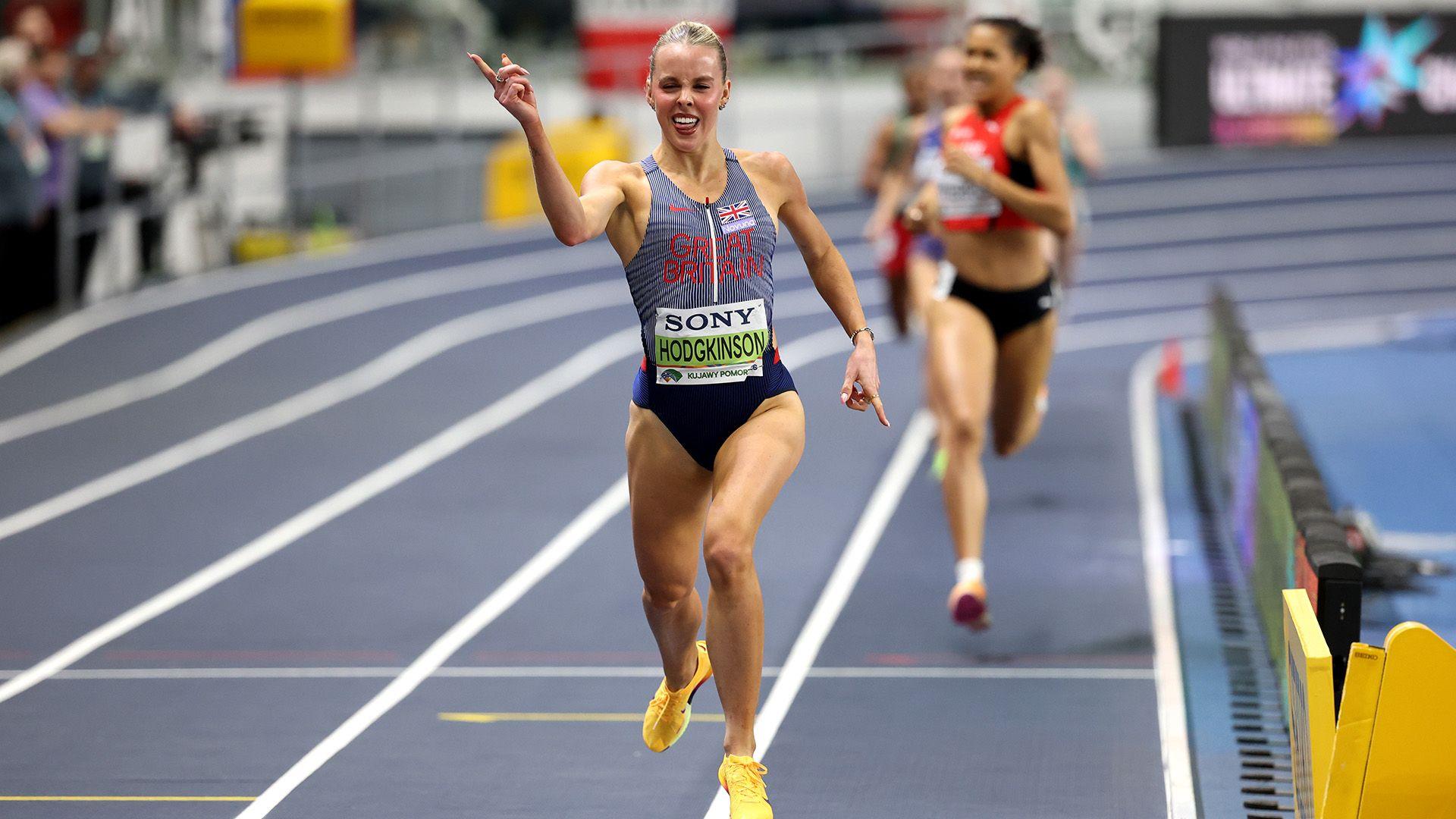 Keely celebrates with a finger pointed in the air as she crosses the finish line of the 800m