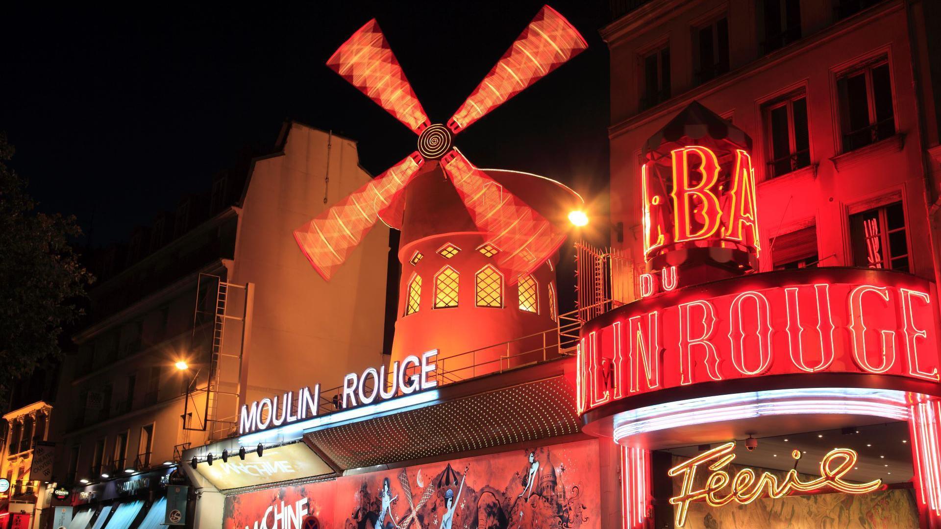 Exterior image of the Moulin Rouge in Paris with its famous windmill on the roof.