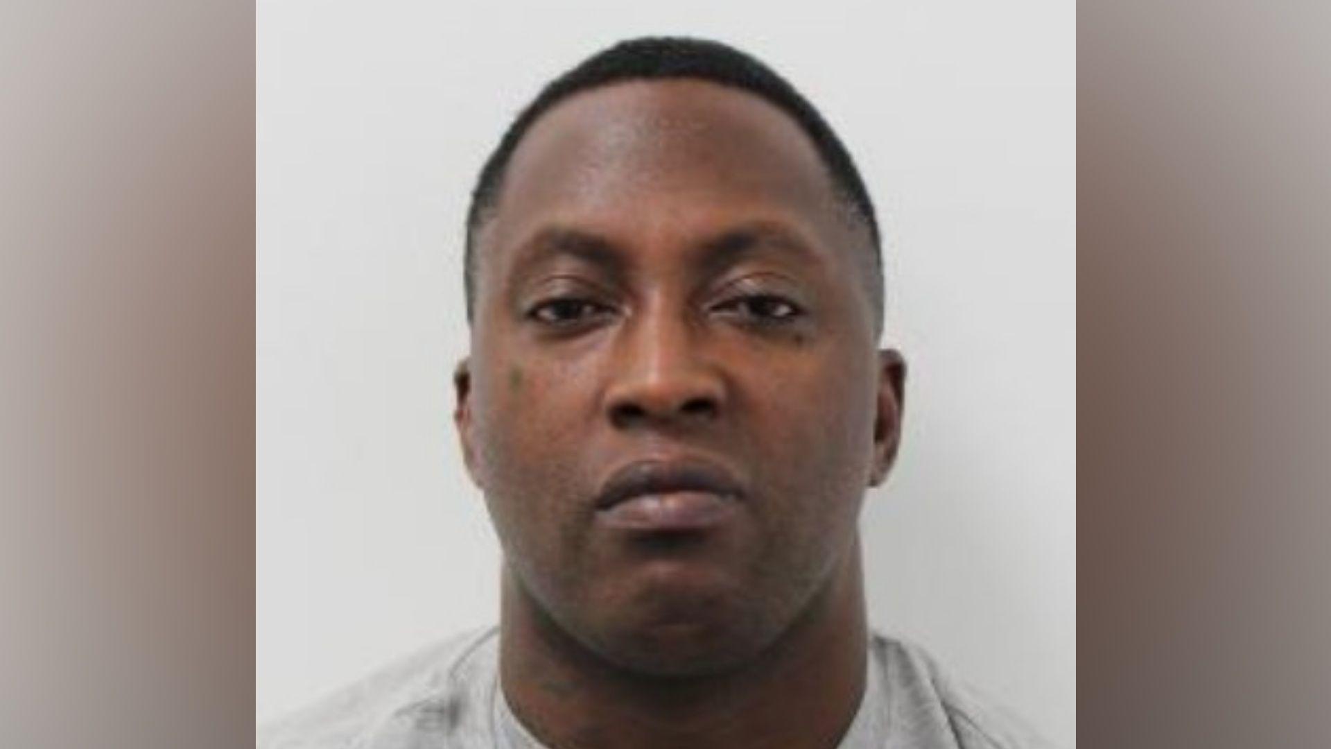 Police custody photograph showing a man facing the camera against a plain light-grey background.