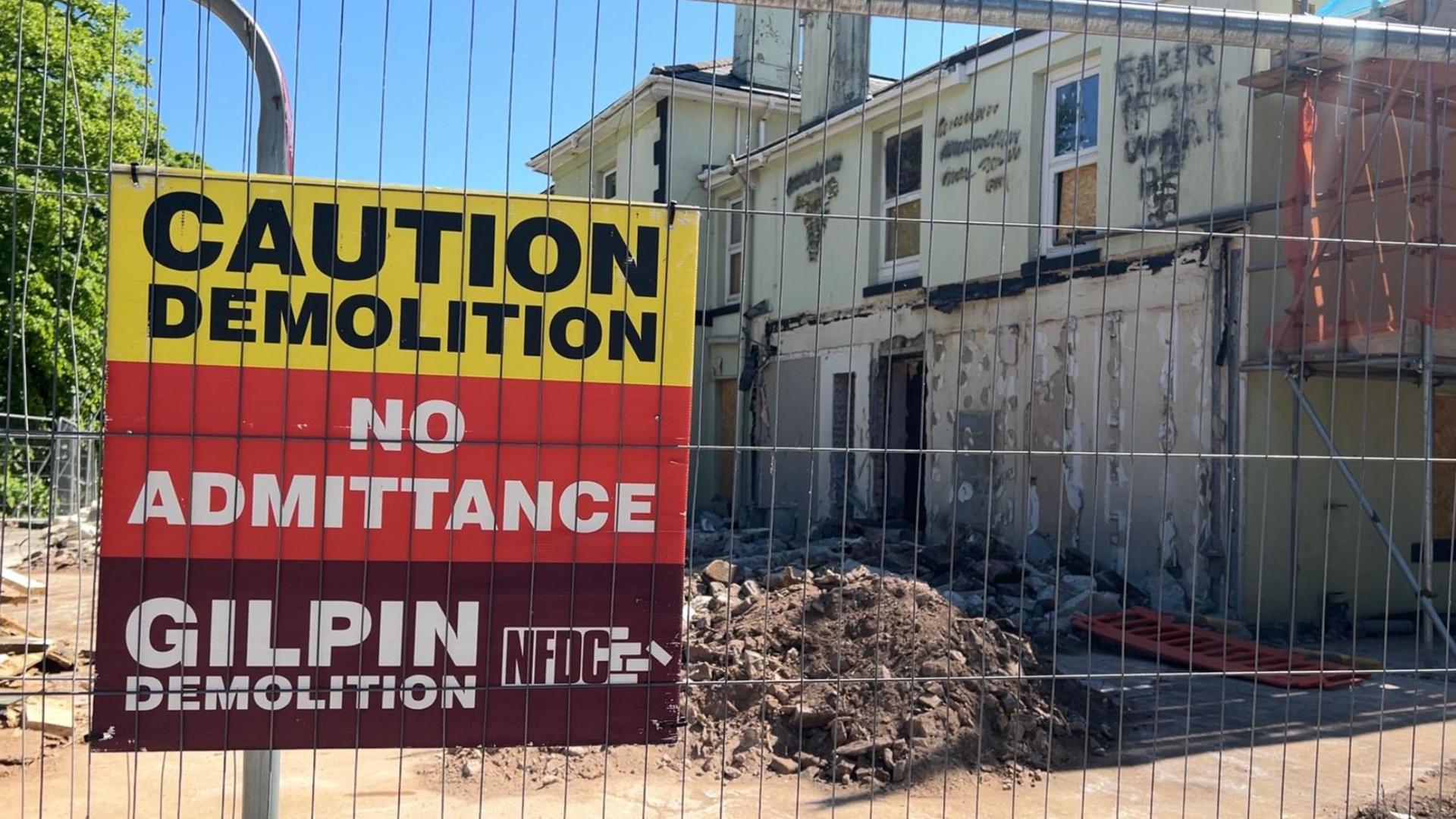 A demolition sign on metal fencing around the Seabury Hotel which is being demolished