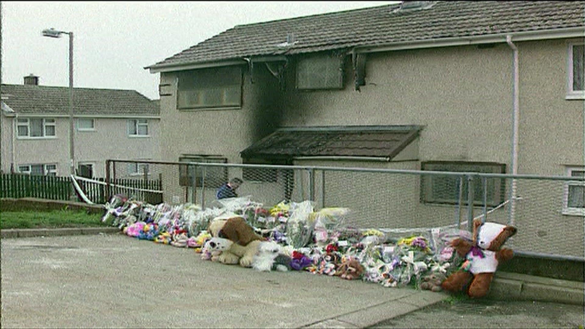 Rhes o flodau a theganau meddwl yn tu allan i'r tŷ wedi marwolaethau Diane Jones a'i phlant