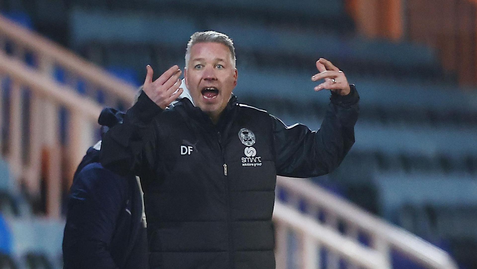 Peterborough manager Darren Ferguson throws his hands up in frustration on the sidelines during a game