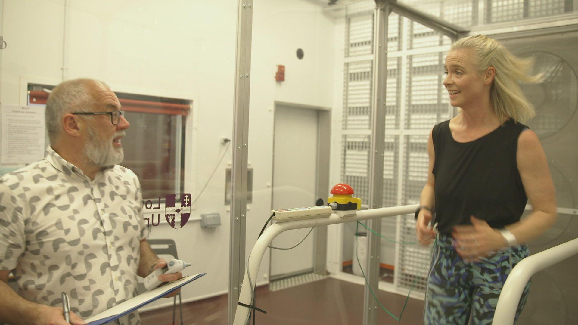 Sarah running on a treadmill in a science laboratory with Dr Simon Hodder holding a clipboard and taking notes