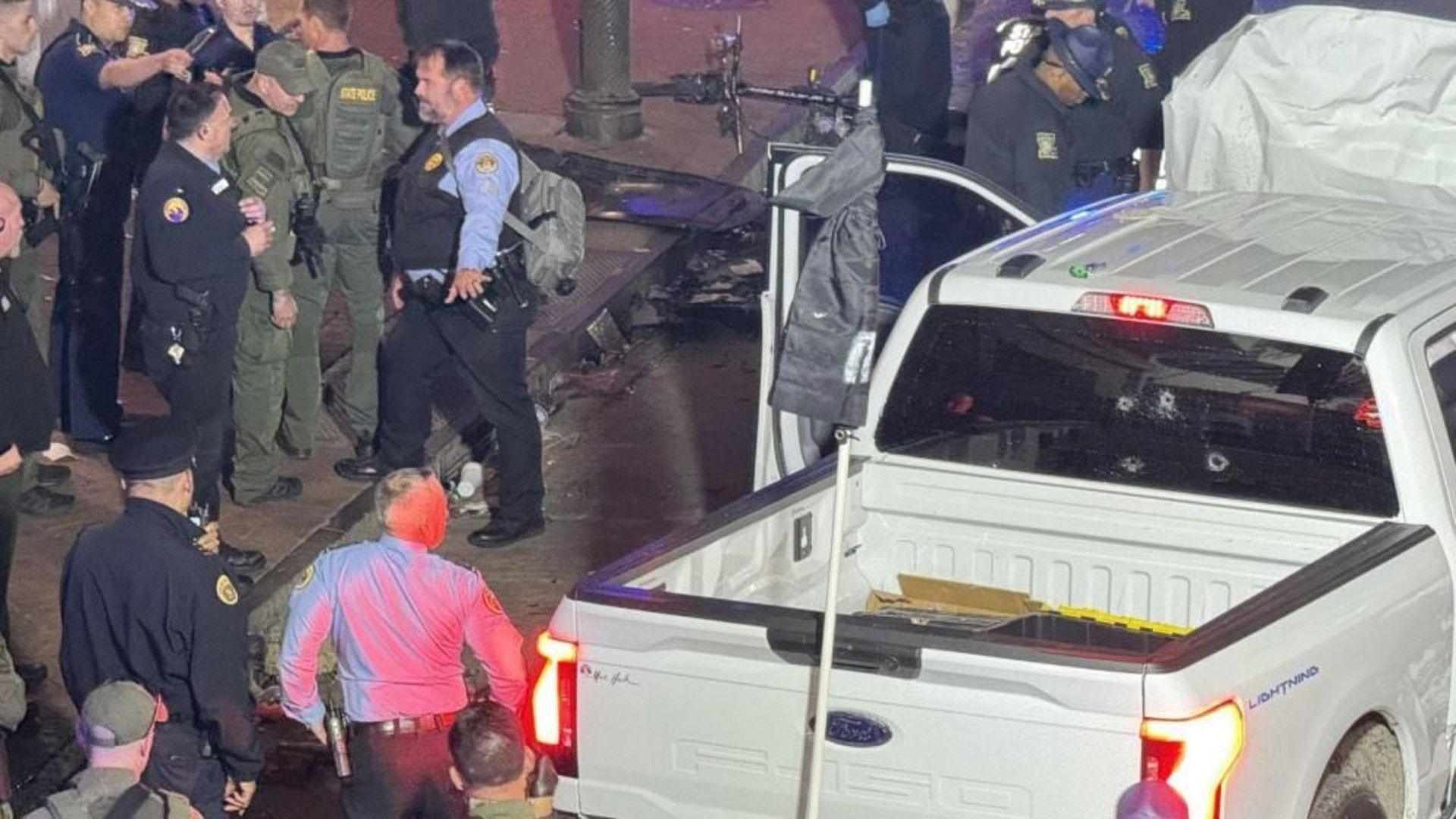 Ford F150 lightning truck, with police officers surrounding it and a heavily damaged bonnet pointing upwards. The driver's door is open.