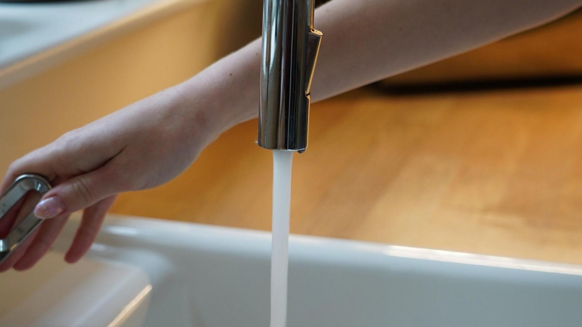 A kitchen tap with water flowing out of it