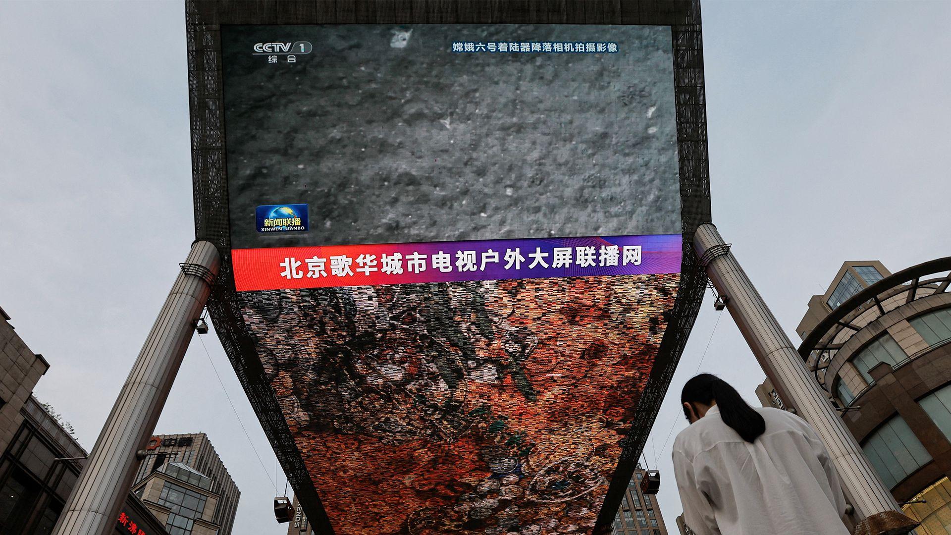 A huge screen on a Chinese street broadcasts footage from the Moon, taken by Chang'e-6