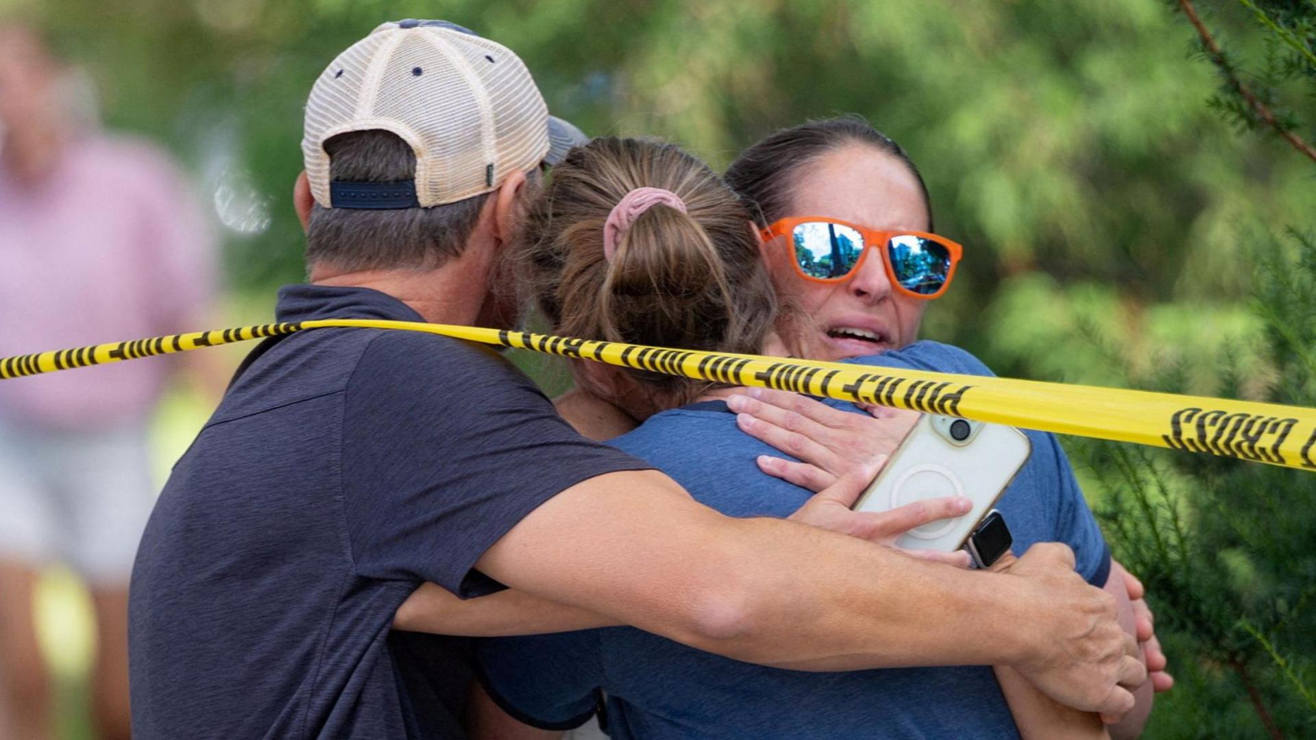 Families and loved ones reunite outside the police barricades after a shooting at Annunciation Church