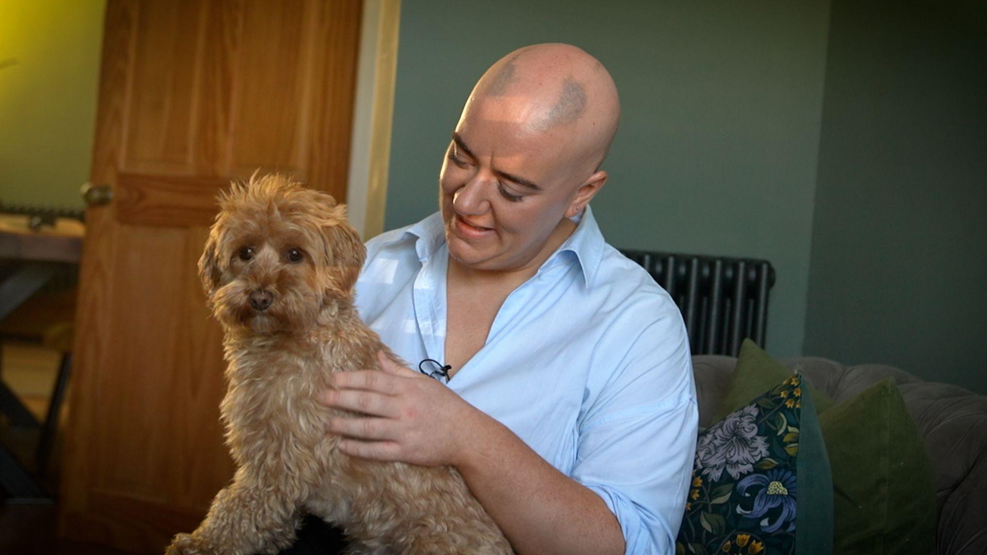 Nicole Thomas with patches on her hair with her dog