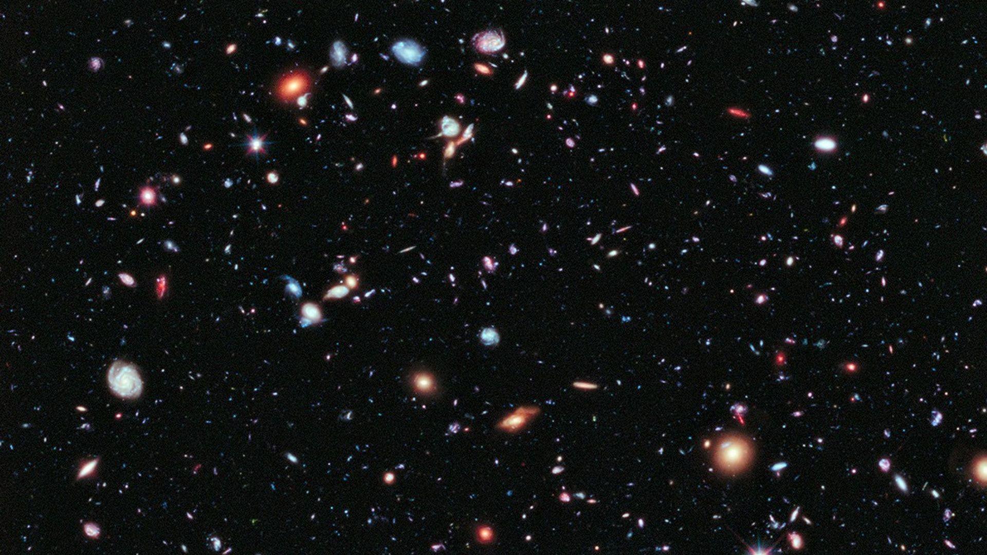 An image of galaxies in the sky, with different coloured stars.