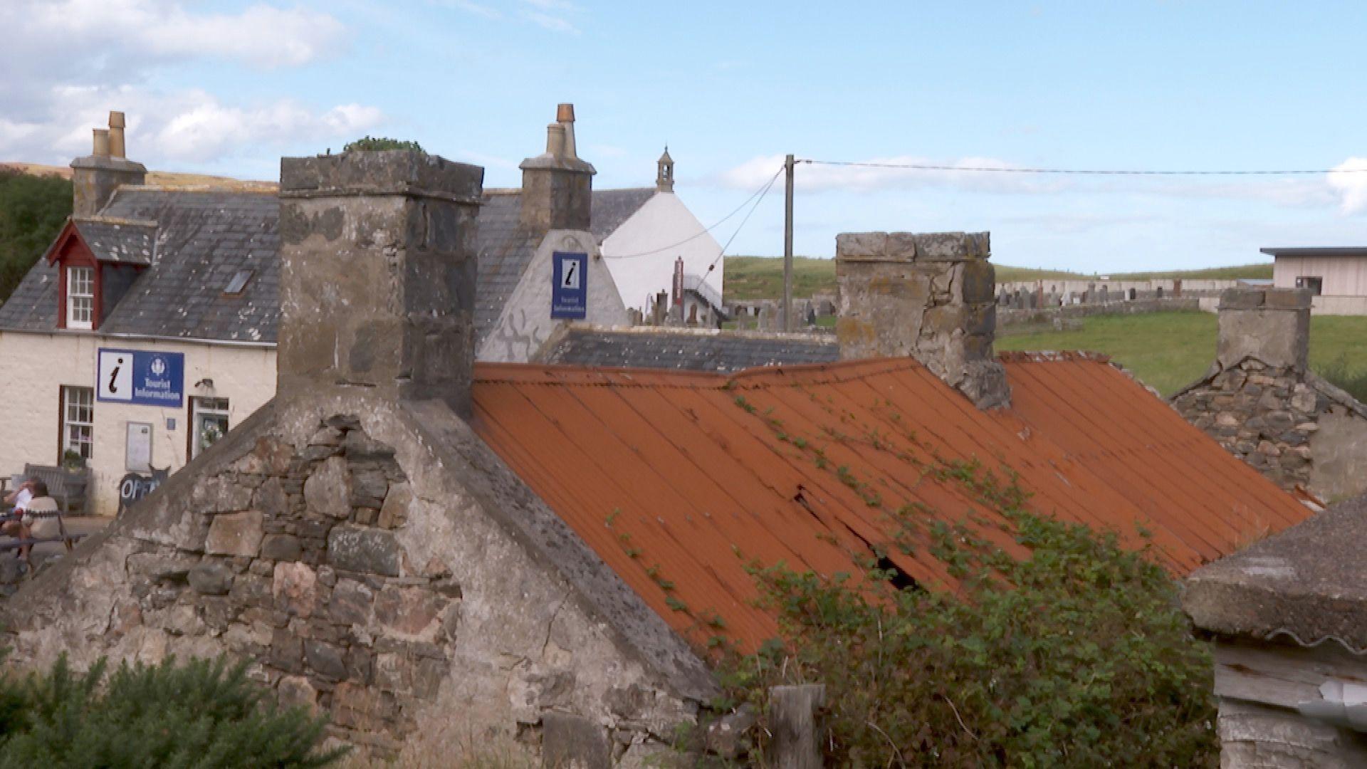 Seann taigh 's ionad-turasachd air a chùlaibh