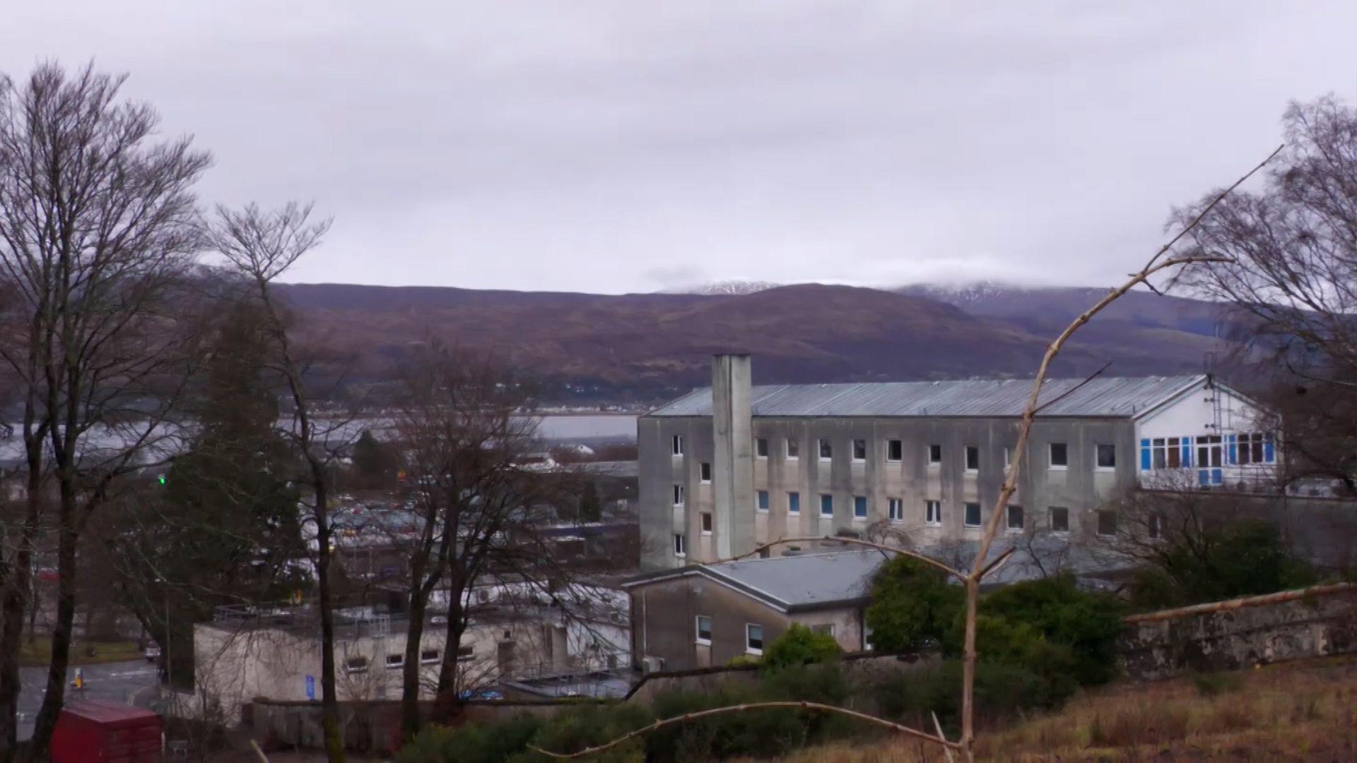 Sean thogalach glas le beanntan air a chùlaibh. 