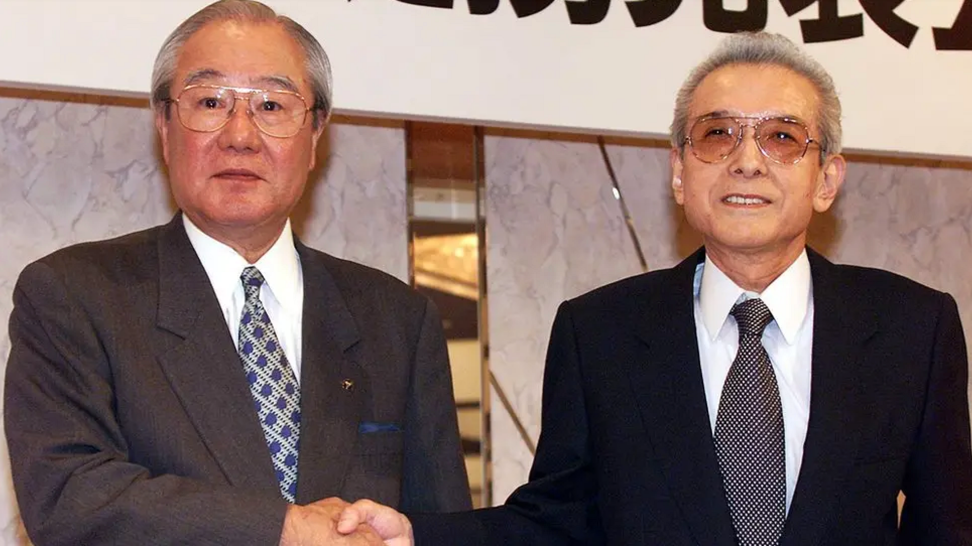 Yoichi Morishita (on the left), the former President of Japan's electronics giant Matsushita, shakes hands with Hiroshi Yamauchi (on the right), the former President of Nintendo