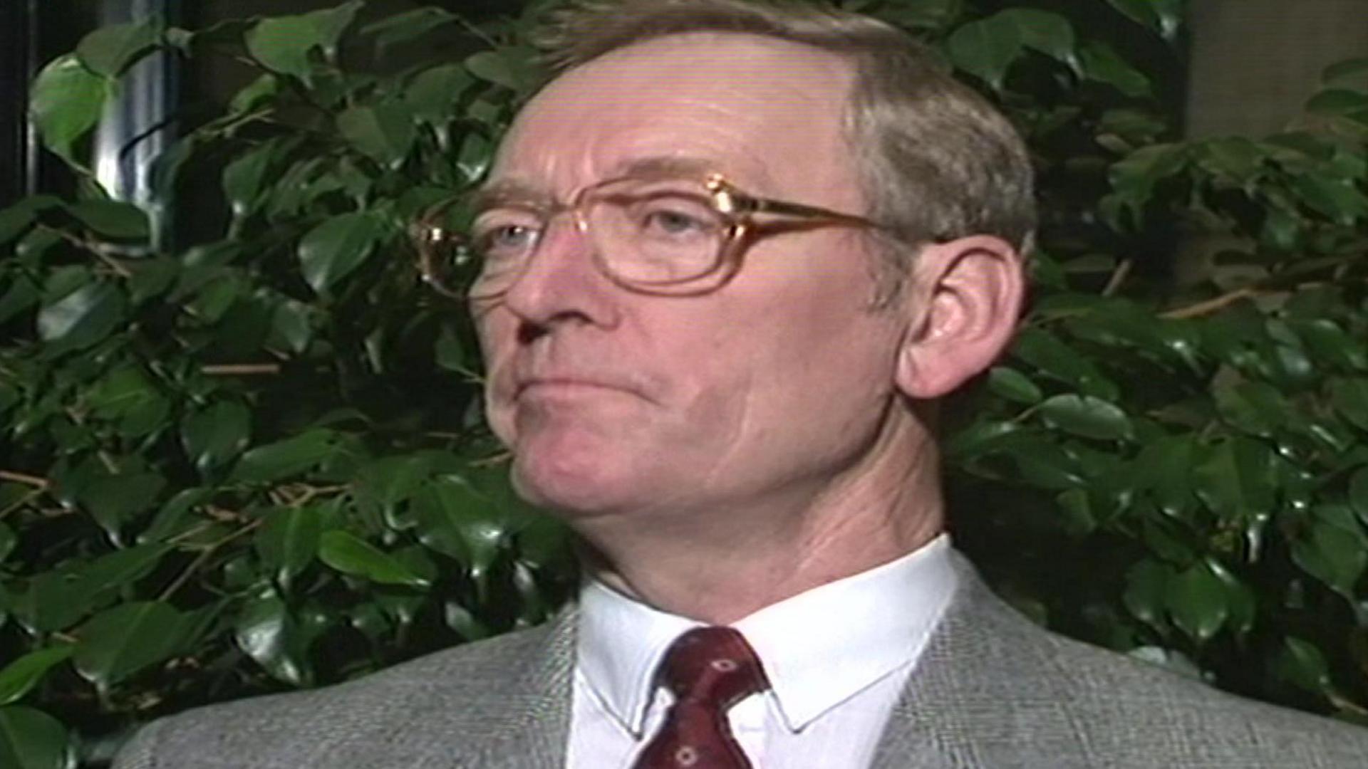 A head and shoulders archive image of George Wright with a leafy green tree in the background behind him