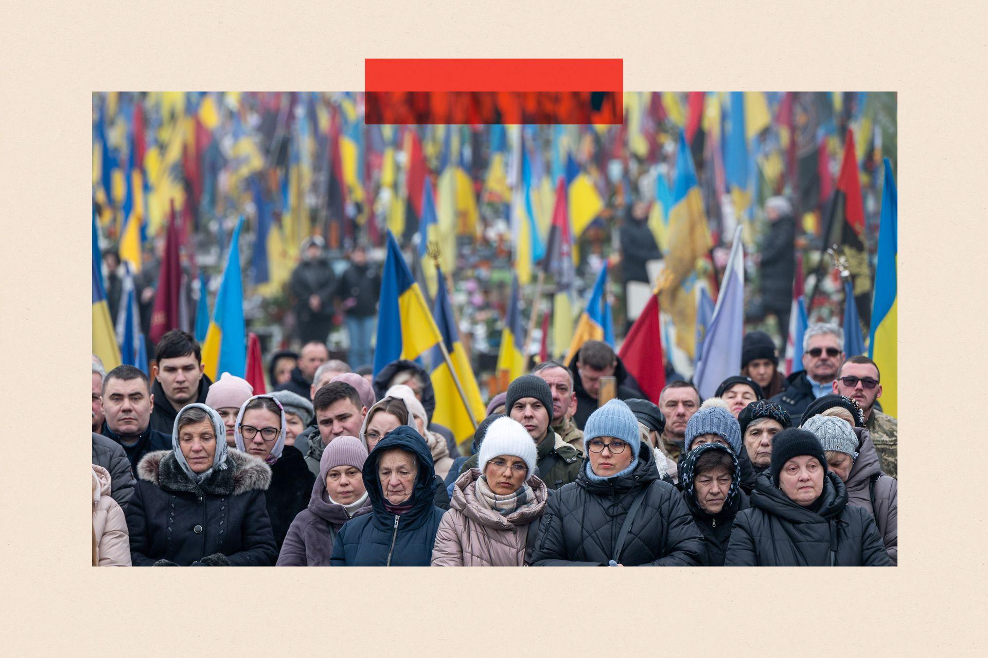People stand near graves during memorial services at the Lychakiv military cemetery in Lviv, Ukraine (2024)