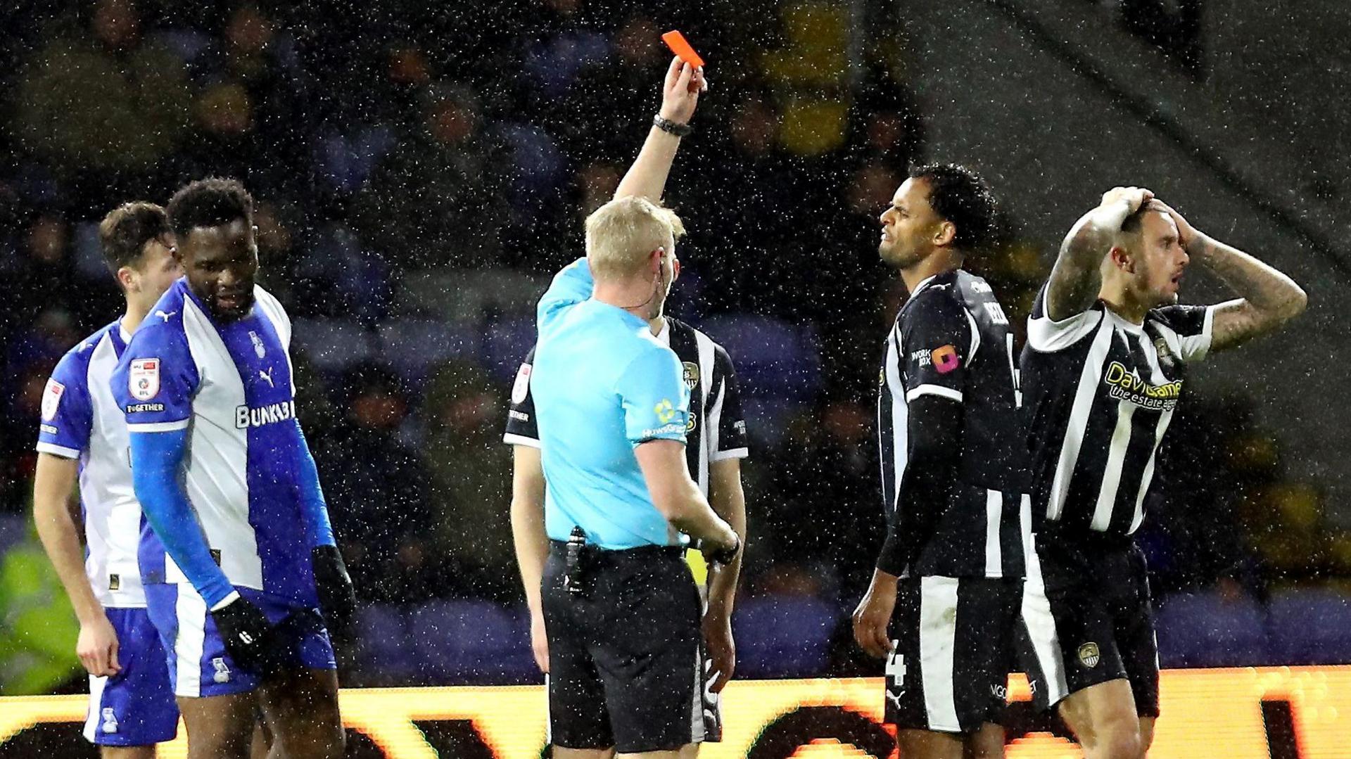 Notts County's Oliver Norburn (second from right) is shown a red card by the referee in the Magpies defeat by Oldham on Tuesday
